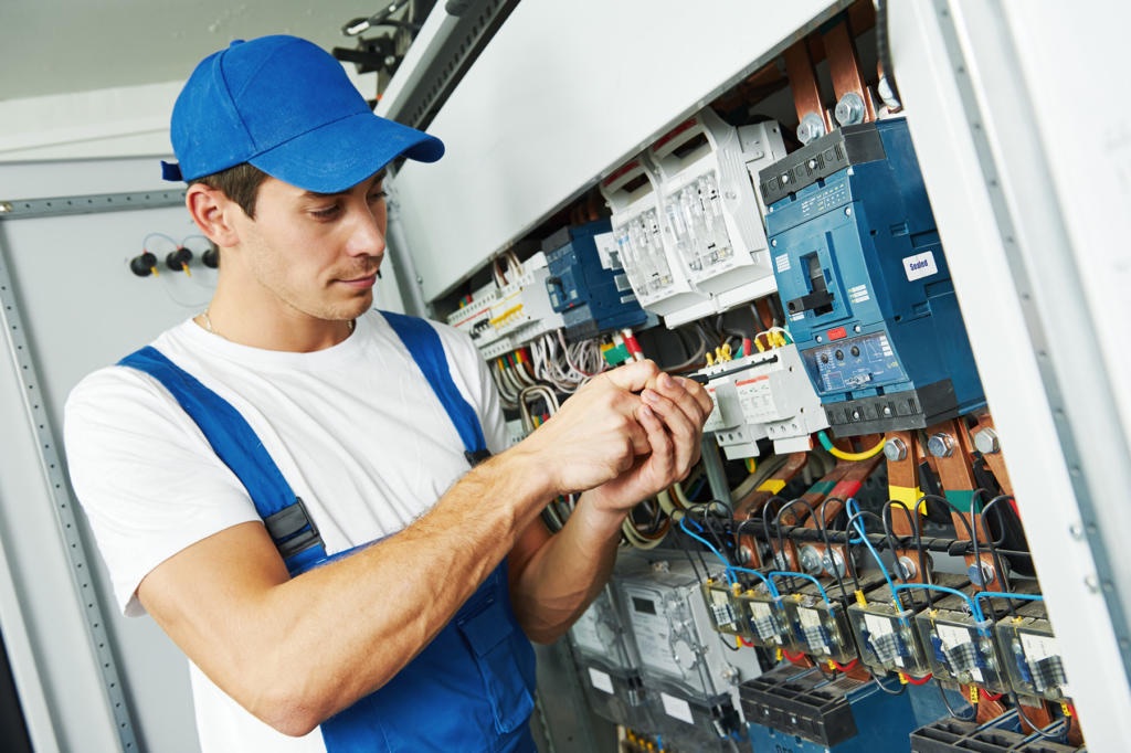 Algemene elektriciteitswerken: elektricien sluit bekabeling aan in een zekeringkast