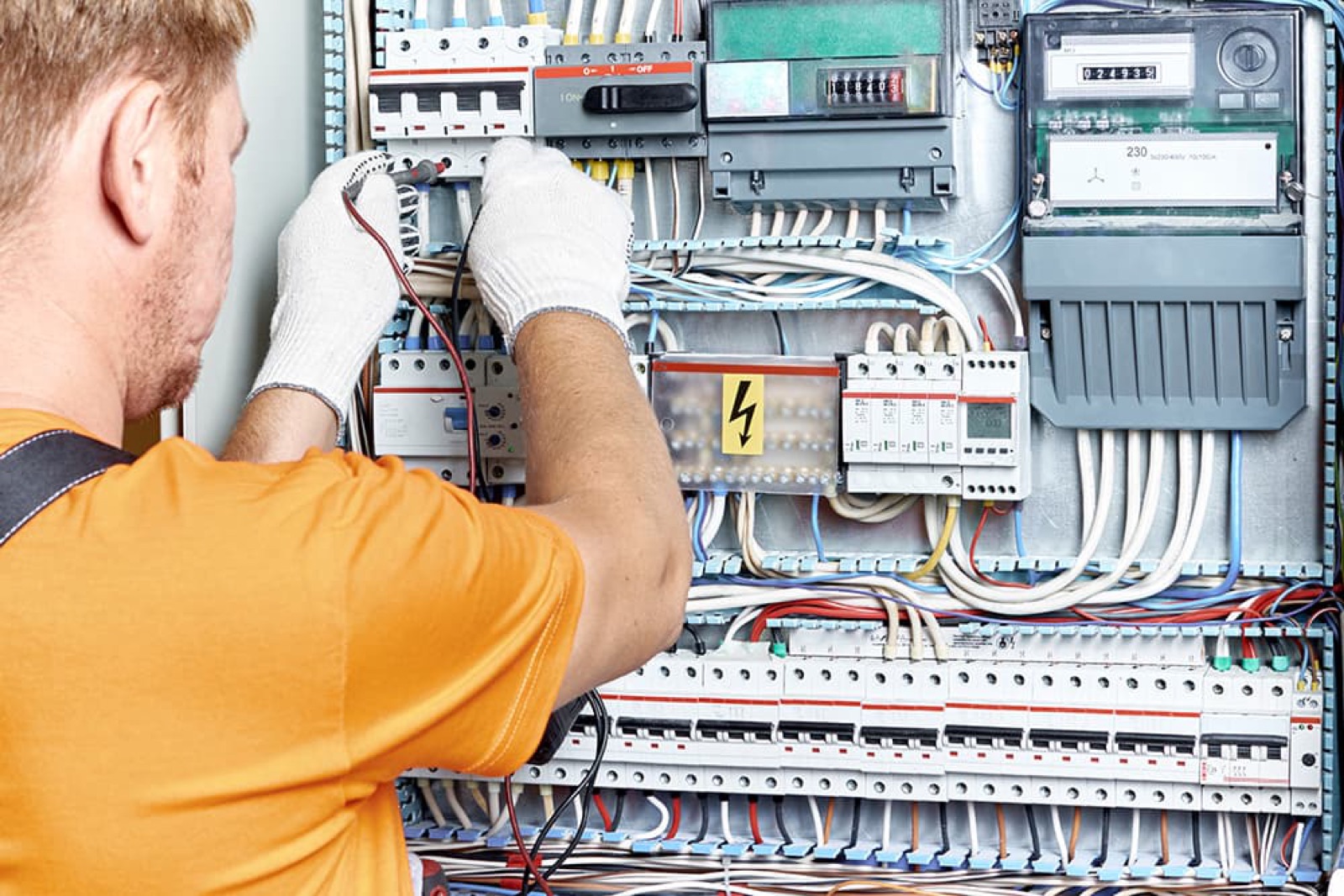Elektricien werkt aan een verdeelkast met automaten en teller
